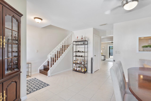 interior space with stairs, light tile patterned floors, baseboards, and visible vents