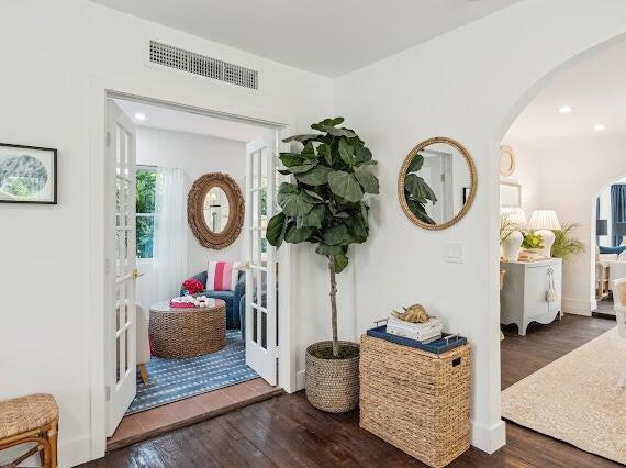 hallway featuring visible vents, recessed lighting, french doors, wood finished floors, and arched walkways