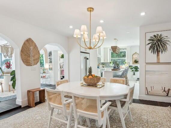 dining room with recessed lighting, arched walkways, and an inviting chandelier