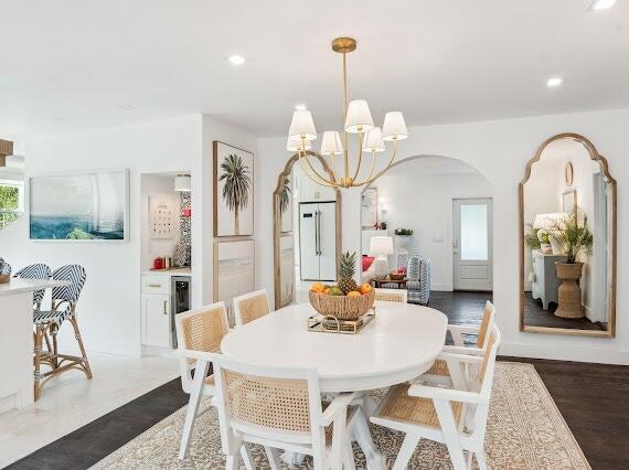 dining area featuring arched walkways, a chandelier, wine cooler, and recessed lighting