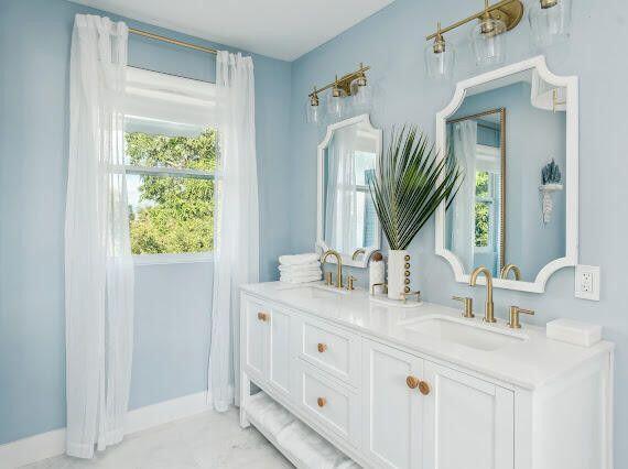 full bathroom featuring double vanity, a wealth of natural light, and a sink