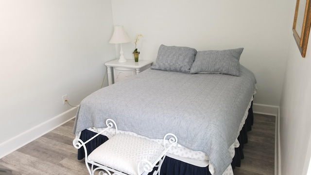 bedroom featuring baseboards and wood finished floors