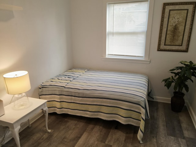 bedroom featuring baseboards and dark wood-style flooring