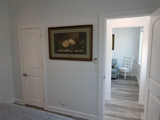 hallway with light wood finished floors and baseboards