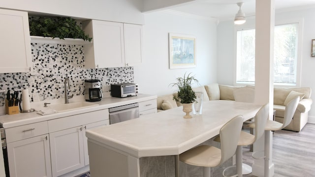 kitchen featuring a sink, crown molding, dishwasher, white cabinets, and open shelves