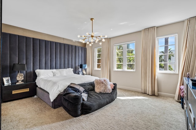 carpeted bedroom with multiple windows, baseboards, and a chandelier