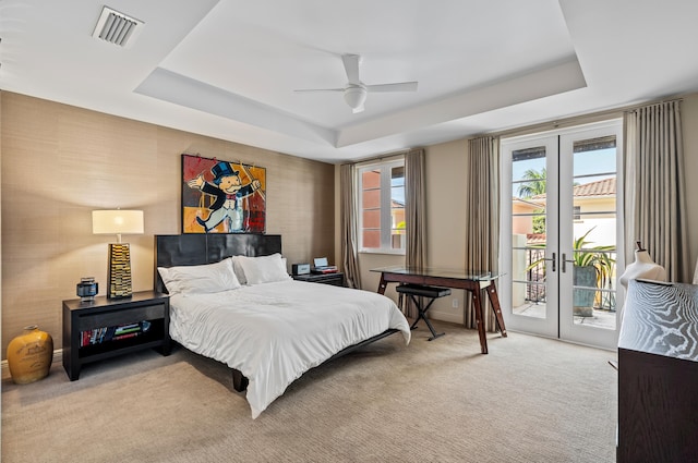 carpeted bedroom with a raised ceiling, access to outside, french doors, and visible vents