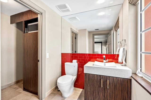 bathroom with vanity, visible vents, tile patterned flooring, tile walls, and toilet