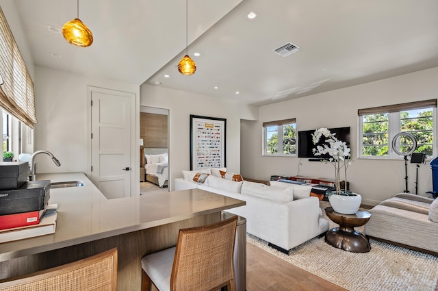 living room with visible vents, recessed lighting, and wood finished floors