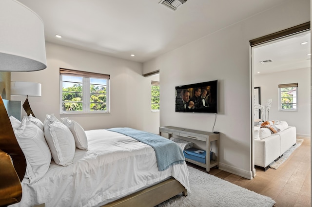 bedroom featuring visible vents, recessed lighting, baseboards, and wood finished floors