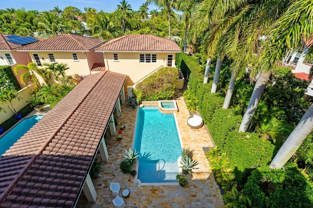 view of pool with a patio, a fenced backyard, and a pool with connected hot tub