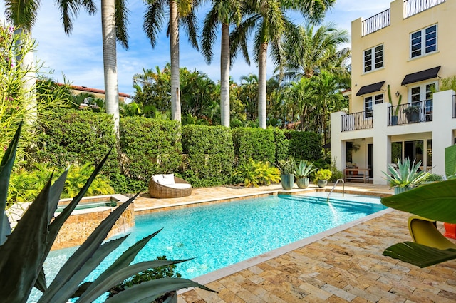 view of swimming pool featuring a fenced in pool, an in ground hot tub, and a patio area