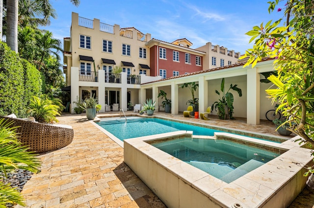 view of swimming pool with a patio area and a pool with connected hot tub