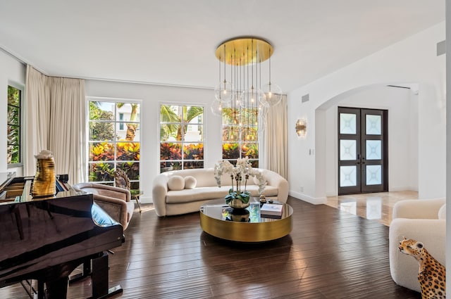 living room with visible vents, french doors, arched walkways, wood-type flooring, and baseboards