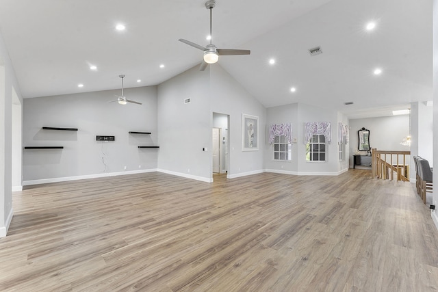 kitchen featuring lofted ceiling, light wood-style floors, appliances with stainless steel finishes, and a peninsula