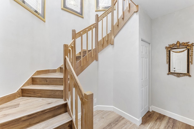 stairway featuring baseboards and wood finished floors