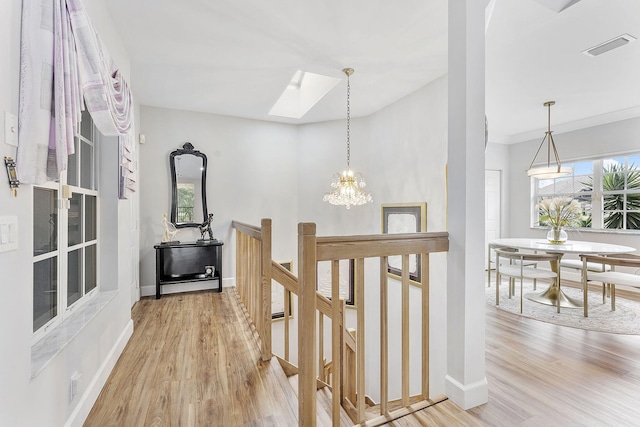 hall featuring baseboards, an upstairs landing, and wood finished floors