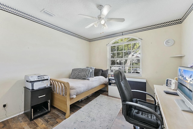 bedroom with visible vents, a textured ceiling, and wood finished floors