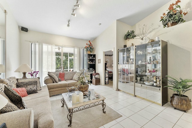 living area with light tile patterned floors, rail lighting, and vaulted ceiling