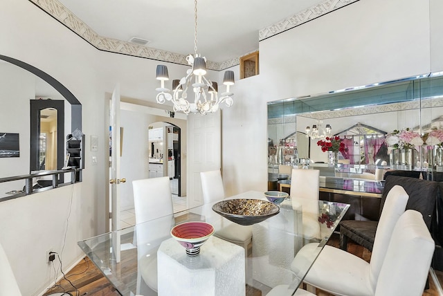 dining space with arched walkways, visible vents, and an inviting chandelier