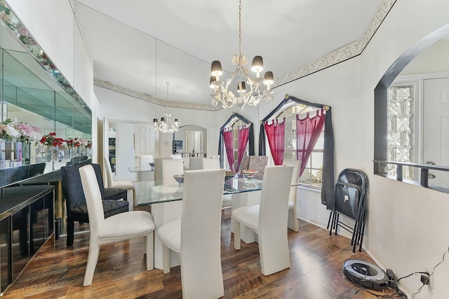 dining area featuring a notable chandelier, wood finished floors, and arched walkways