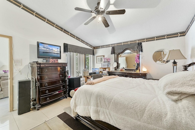 tiled bedroom with ceiling fan and lofted ceiling