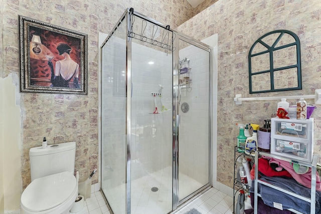 full bathroom featuring wallpapered walls, a shower stall, toilet, and tile patterned flooring