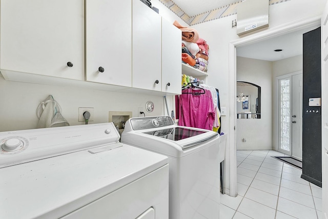 laundry area featuring light tile patterned flooring, cabinet space, and independent washer and dryer