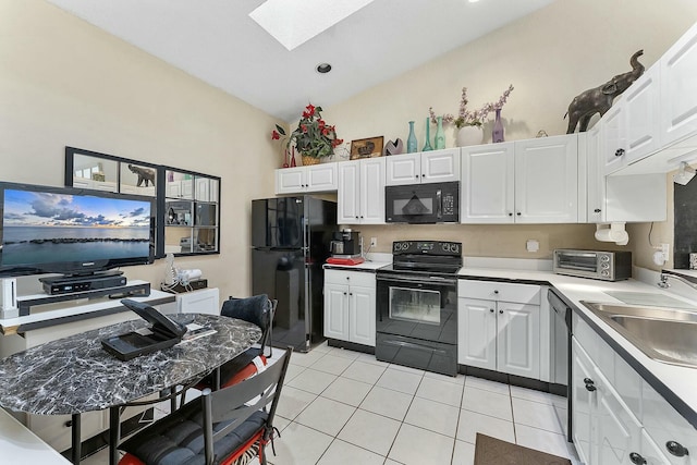 kitchen with light countertops, light tile patterned flooring, white cabinets, black appliances, and a sink