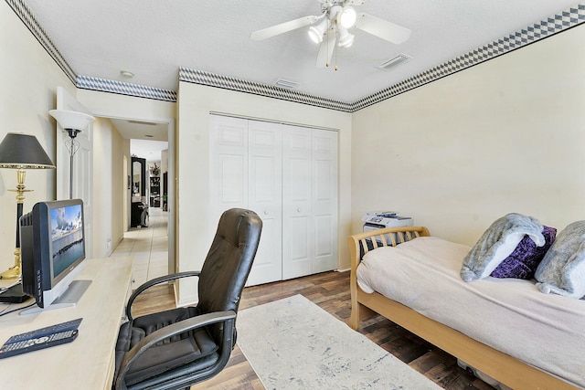 office area featuring a ceiling fan, wood finished floors, visible vents, and a textured ceiling