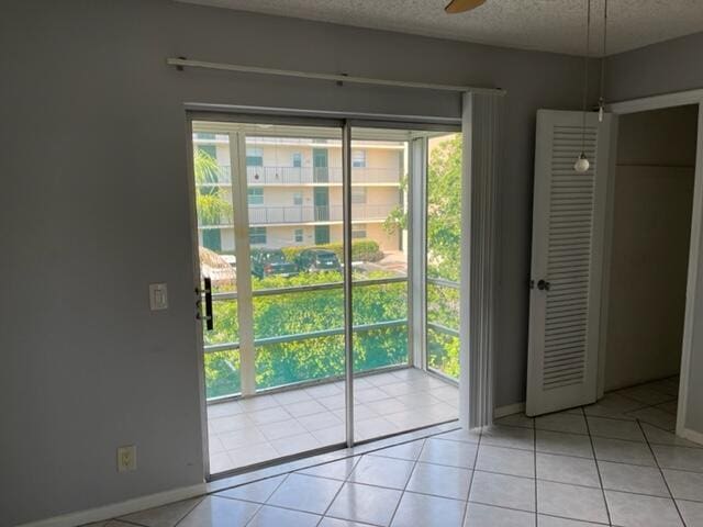 entryway with light tile patterned floors, a textured ceiling, and a healthy amount of sunlight