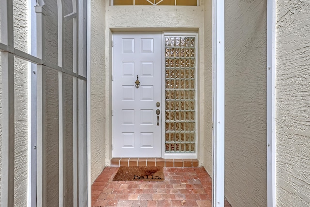 doorway to property featuring stucco siding