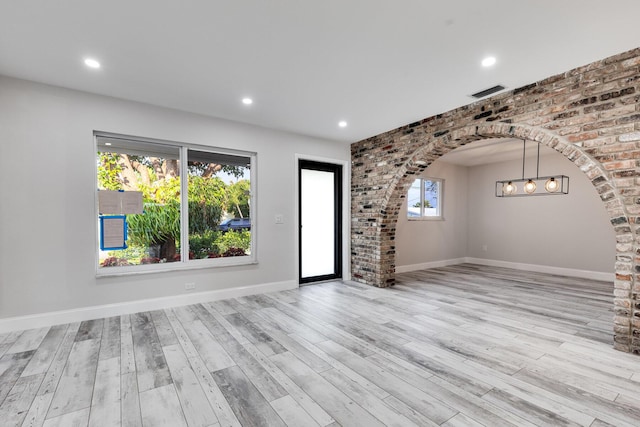 interior space with arched walkways, recessed lighting, baseboards, and wood finished floors