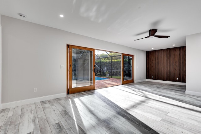 spare room featuring recessed lighting, light wood-style flooring, and baseboards