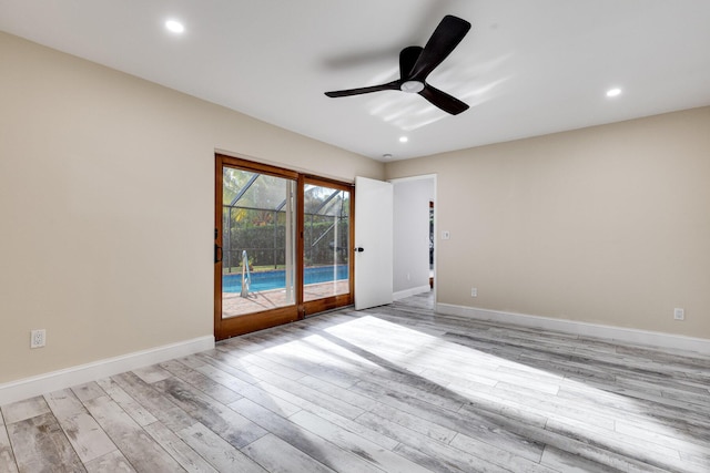 spare room featuring recessed lighting, light wood-type flooring, baseboards, and a ceiling fan