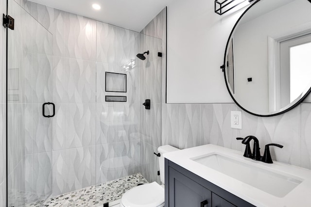 full bath with a shower stall, tile walls, toilet, decorative backsplash, and vanity