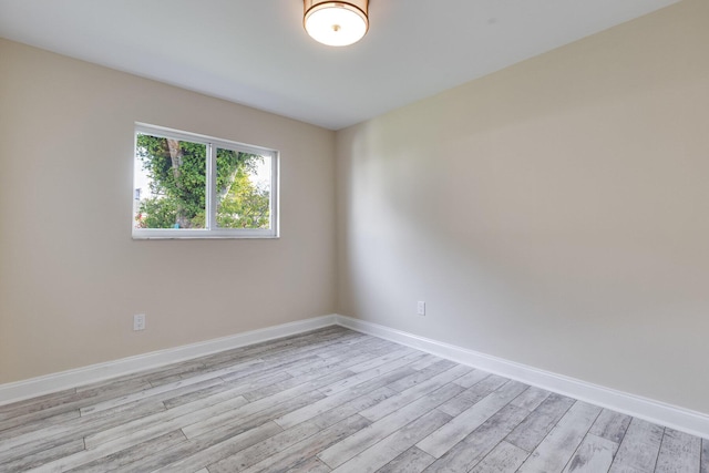 empty room with baseboards and light wood finished floors