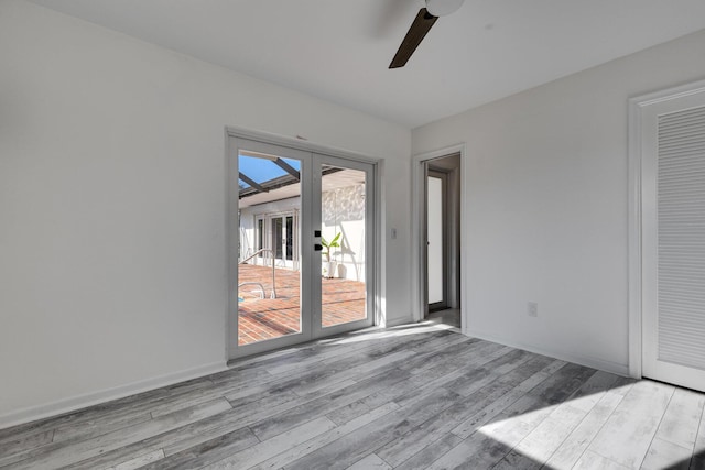 empty room with baseboards, light wood finished floors, and ceiling fan