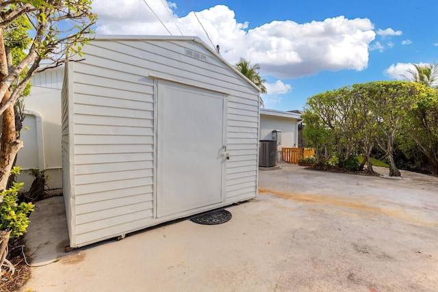 view of shed featuring cooling unit and fence