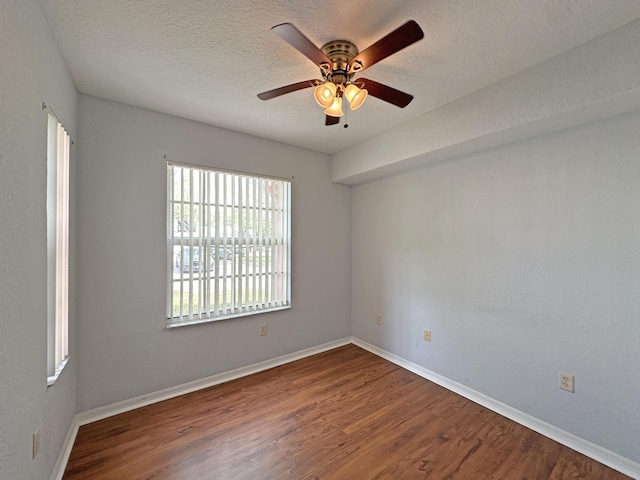 unfurnished room with a ceiling fan, wood finished floors, baseboards, and a textured ceiling