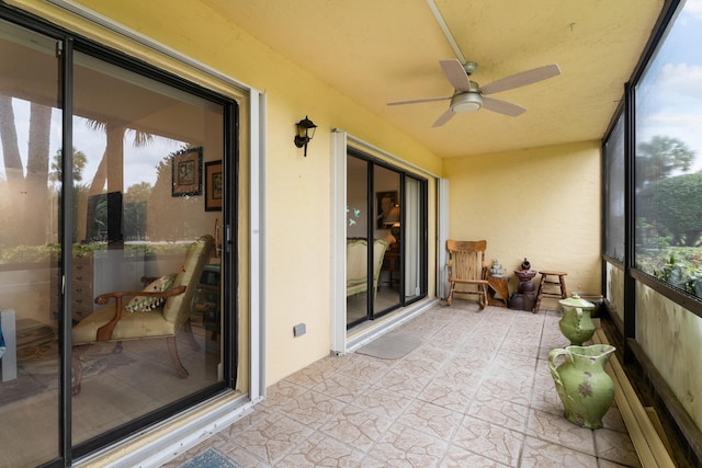 sunroom / solarium featuring a ceiling fan