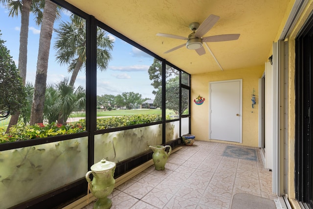 unfurnished sunroom with ceiling fan