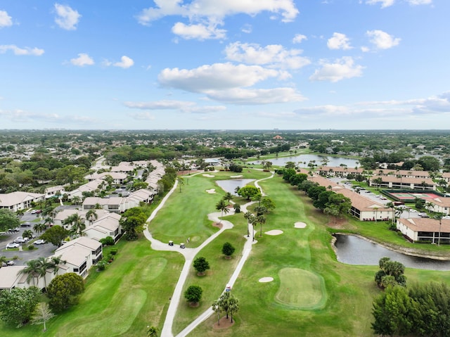 drone / aerial view with a residential view, golf course view, and a water view