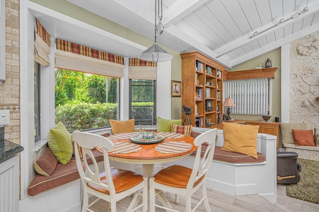 dining space featuring light wood-style flooring, vaulted ceiling with beams, and wood ceiling