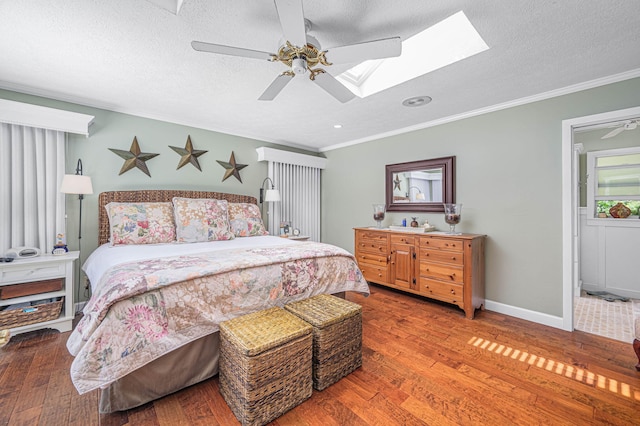 bedroom featuring a textured ceiling, crown molding, baseboards, and wood finished floors