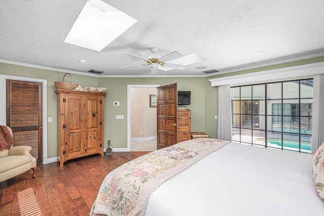 bedroom featuring a skylight, crown molding, and wood finished floors