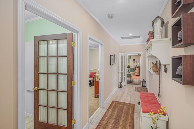 hall featuring light wood-style flooring, baseboards, ornamental molding, and french doors