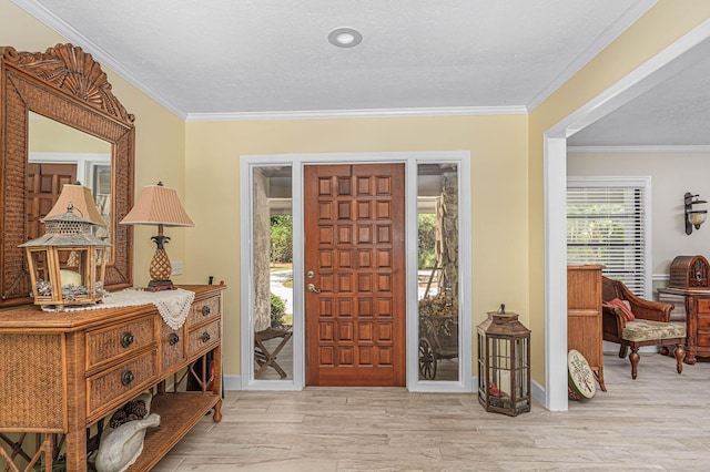 foyer entrance featuring crown molding, baseboards, and wood finished floors