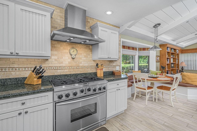 kitchen with high end range, light wood-style flooring, vaulted ceiling with beams, decorative backsplash, and wall chimney exhaust hood