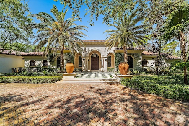 mediterranean / spanish home with stucco siding and a tile roof